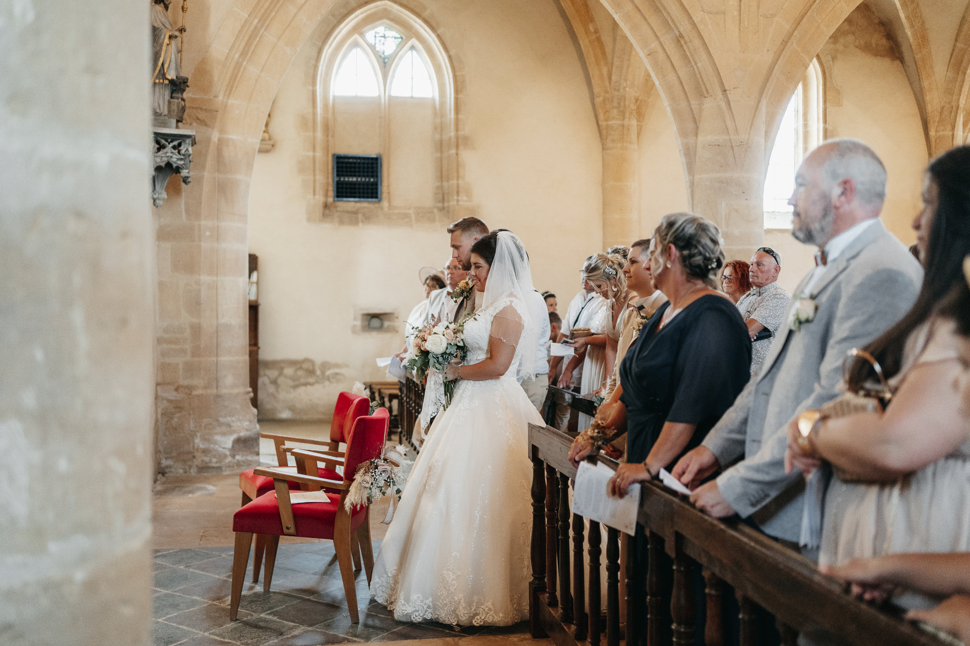 Une mariée et un marié marchant dans l'allée d'une église.