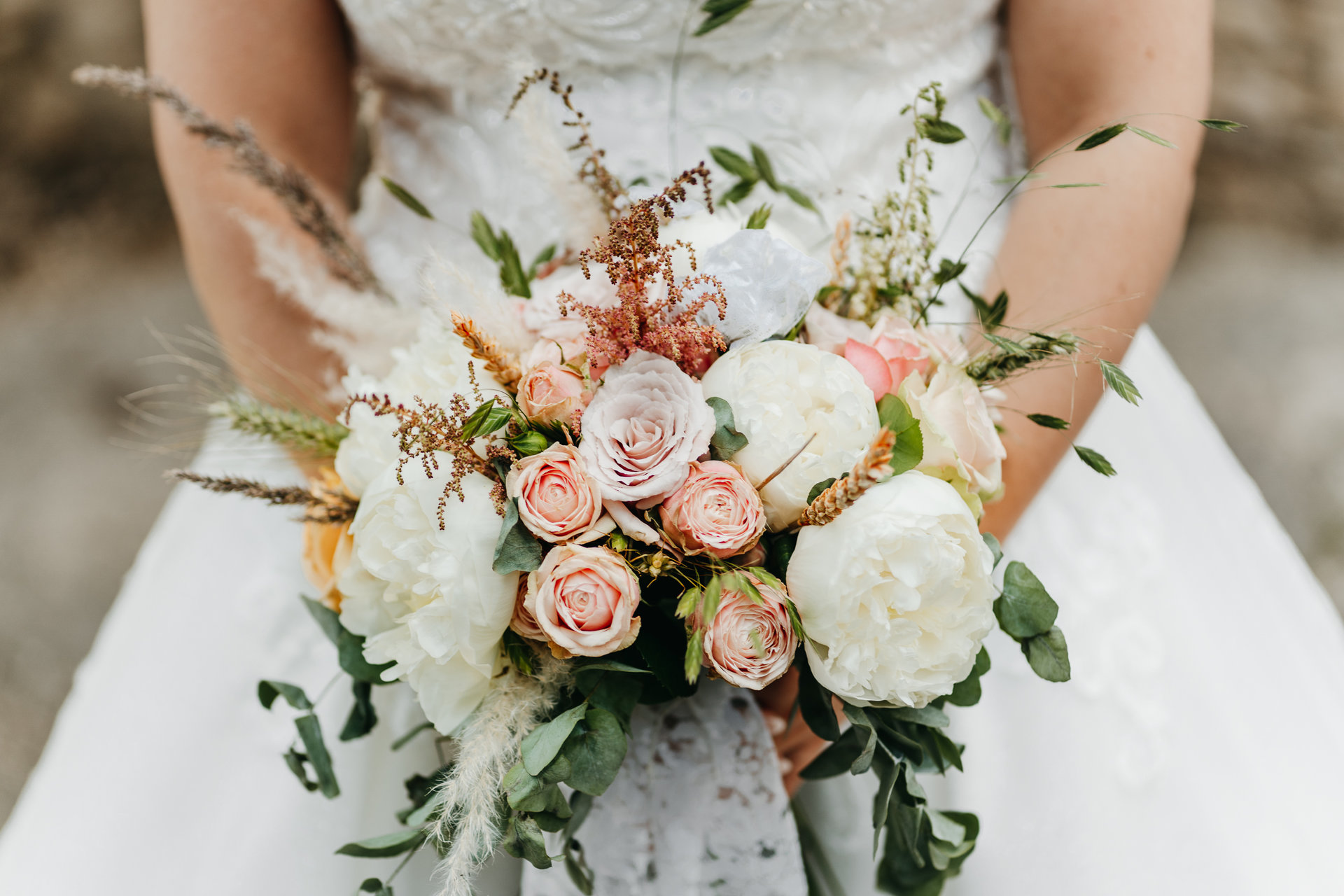 Une mariée tenant un bouquet de fleurs.