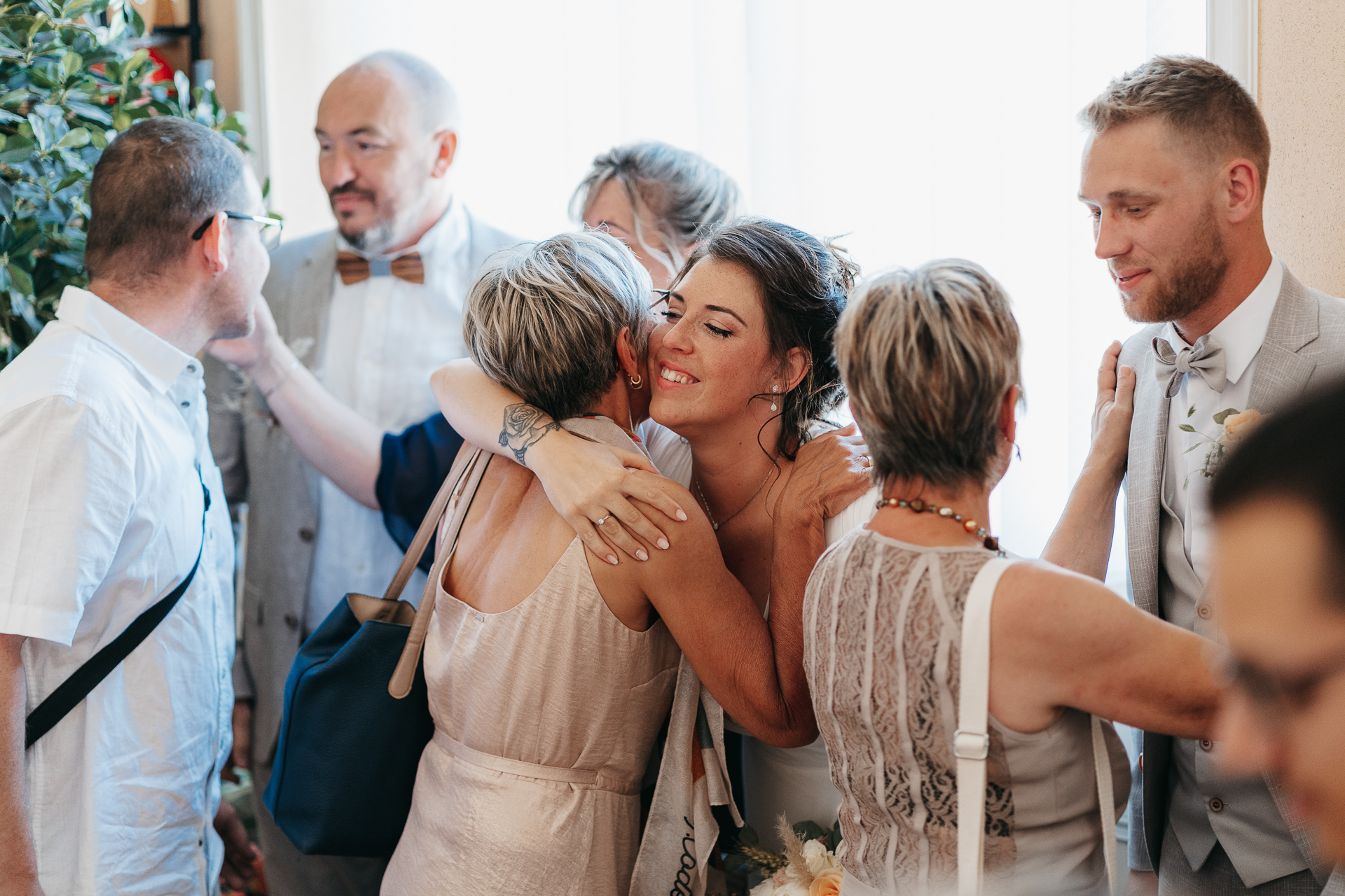 Un groupe de personnes s'embrassant lors d'une réception de mariage.