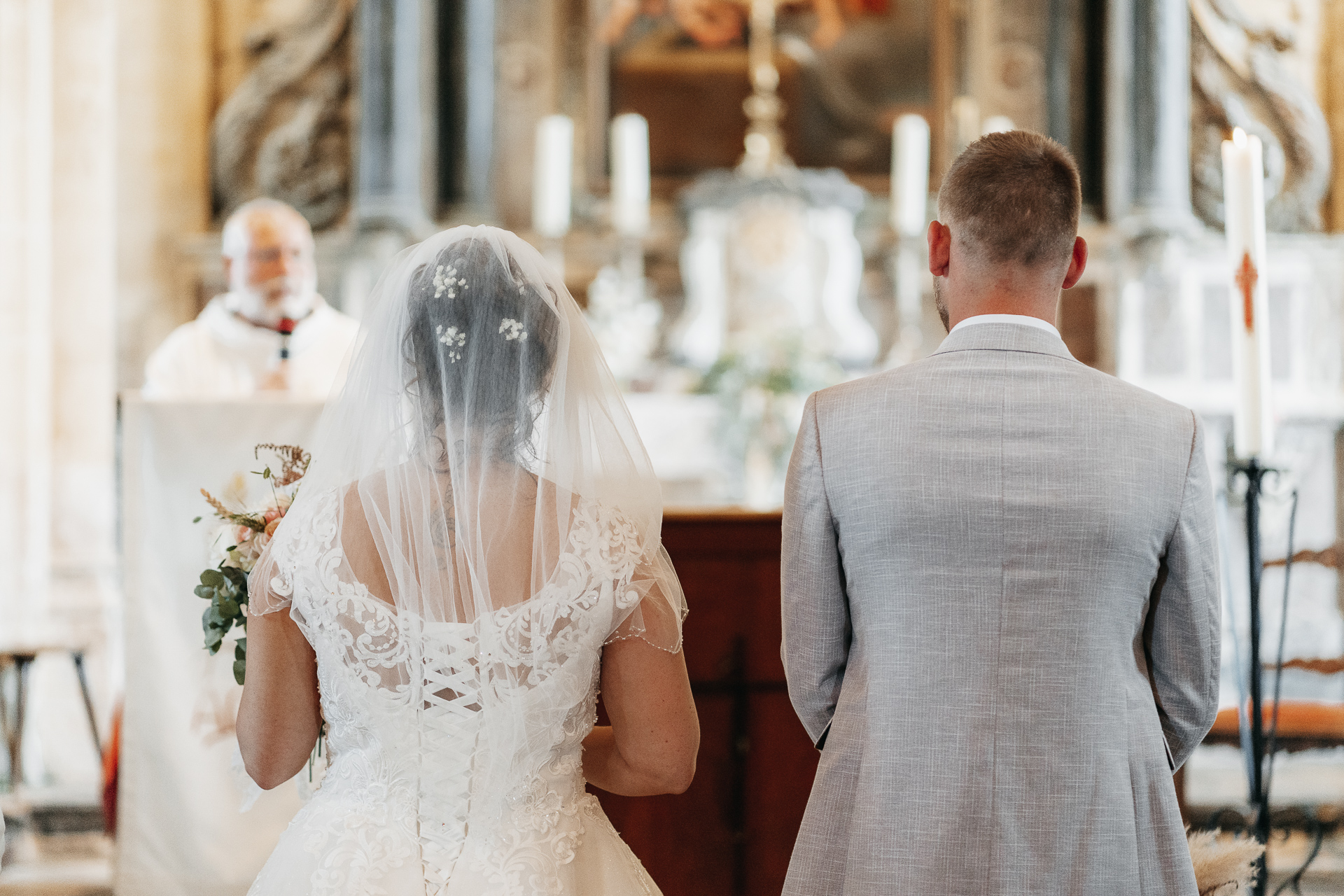 Une mariée et un marié se regardent dans une église.