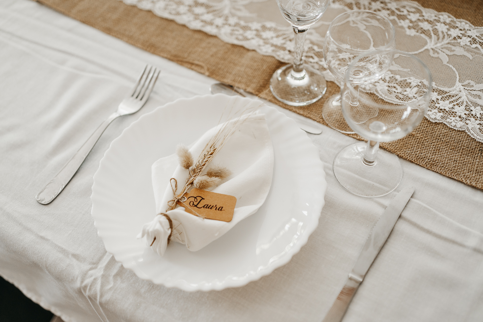 Une table avec une assiette blanche et de l'argenterie.
