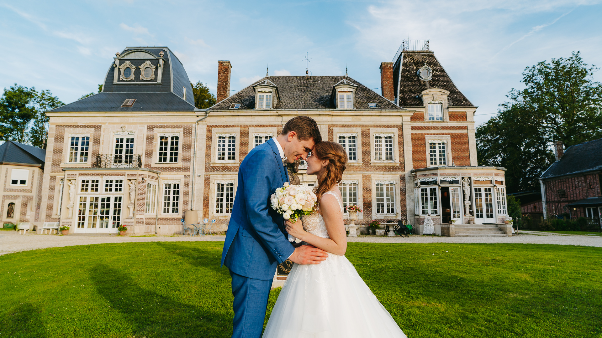 Des mariés s'embrassant devant le château de Montaubois.