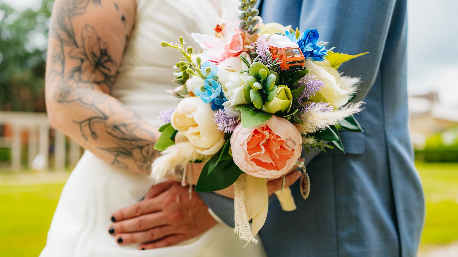Une mariée et un marié tatoués tenant un bouquet.