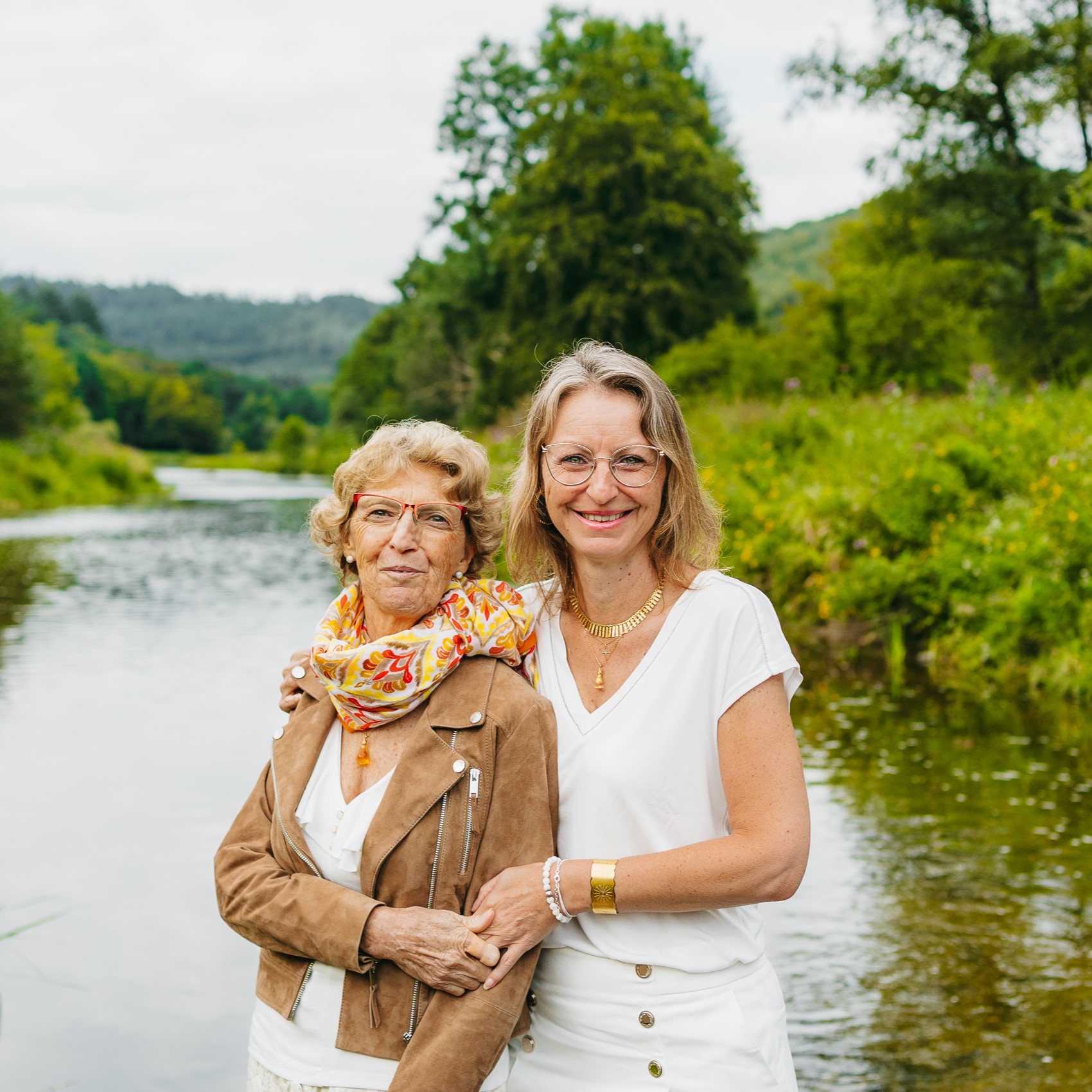 Deux femmes âgées debout au bord d’une rivière.