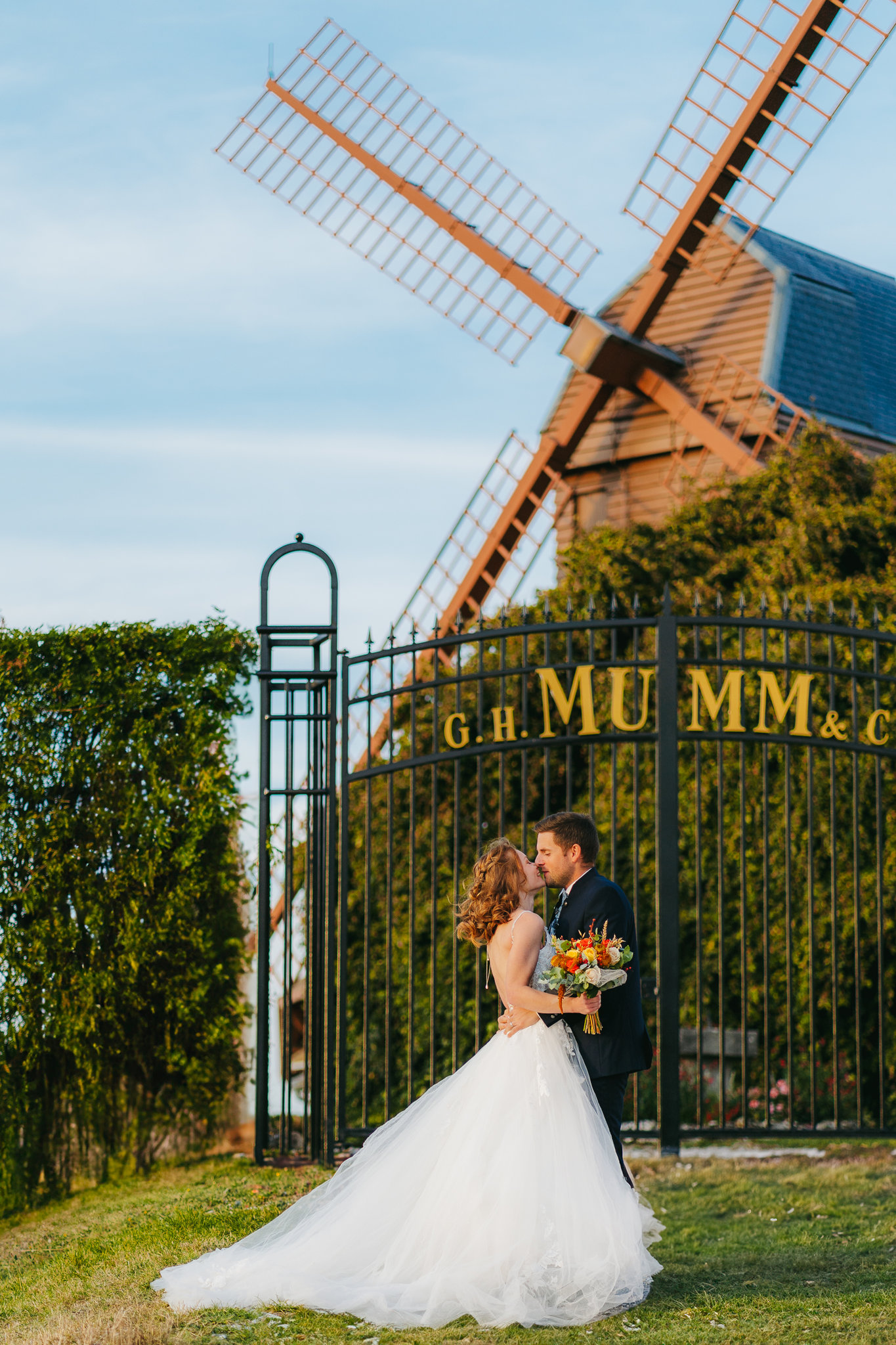 Les mariés partagent un moment intime au bord d’un moulin à vent.